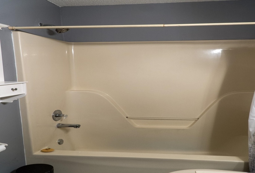 Integrated tub and shower combination unit featuring a showerhead and chrome fixtures