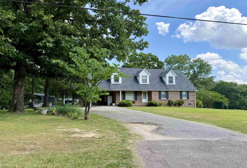 Brick exterior residence with a dormer roofline and a paved driveway