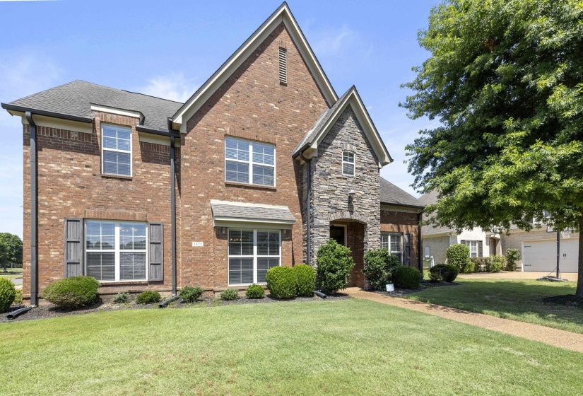 Brick and stone veneer exterior with a gabled roofline