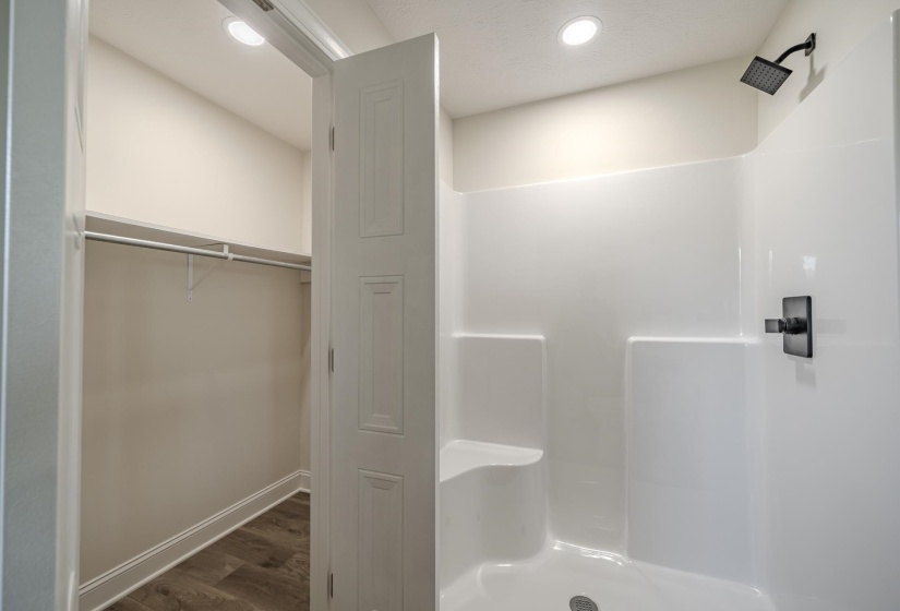 Shower enclosure featuring a built-in bench, black-finish showerhead, and a single handle control