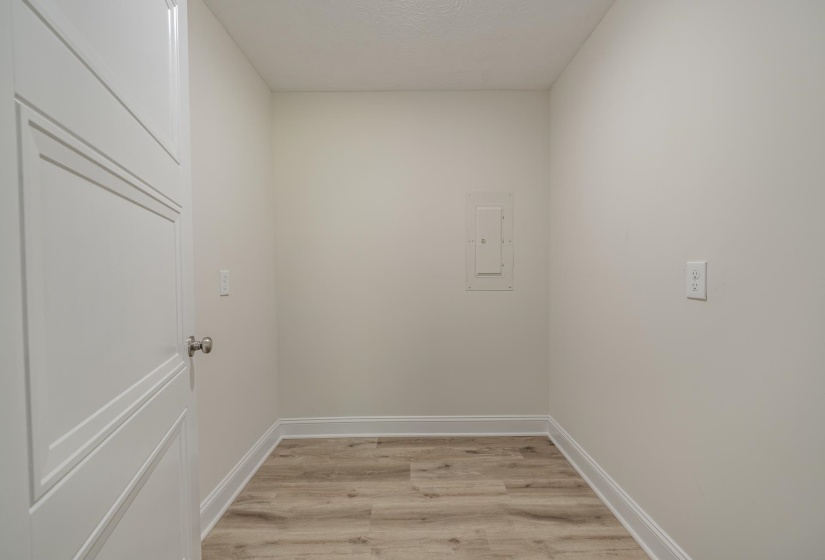 Interior space with wood-finish flooring, light-toned walls, and white baseboards