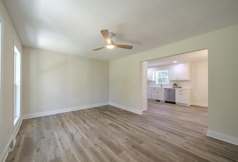 Spacious room with wood-finish flooring and a ceiling fan with integrated lighting