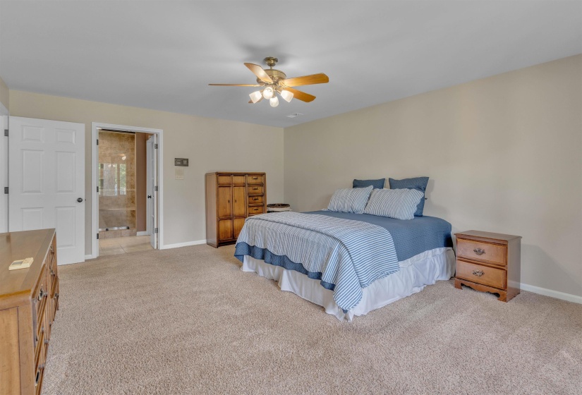 Carpeted interior space with a ceiling fan featuring integrated lighting