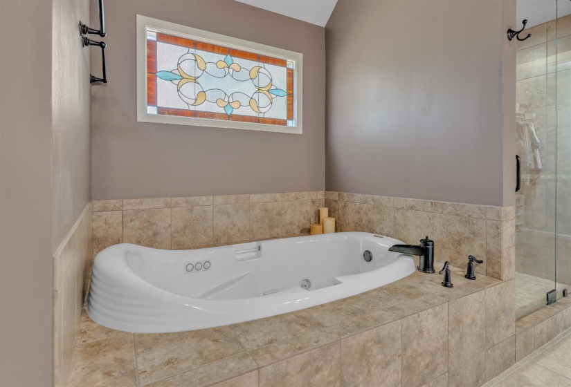 Soaking tub with jetted features, surrounded by large format tile