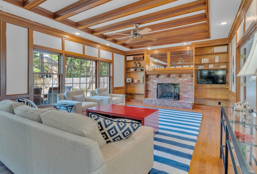 Living space featuring wood-finish flooring, a wood coffered ceiling, and substantial wood-trimmed windows