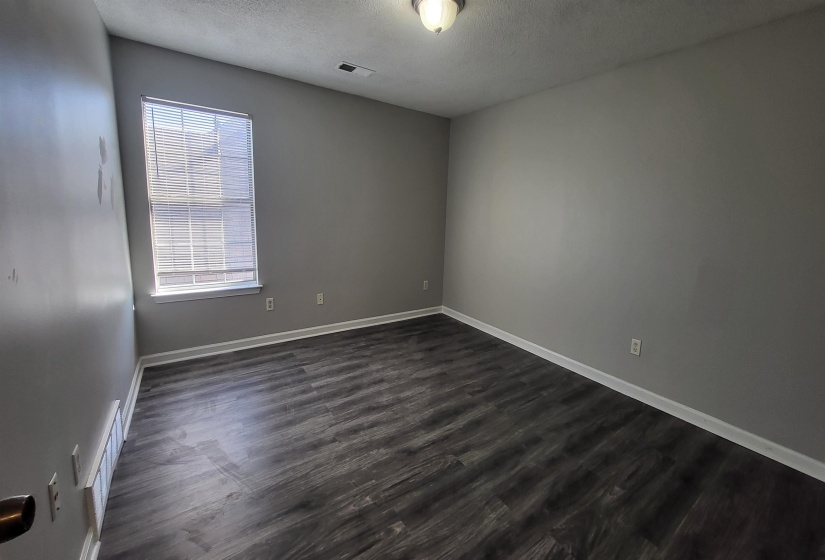 Spare room featuring dark hardwood / wood-style floors and a textured ceiling