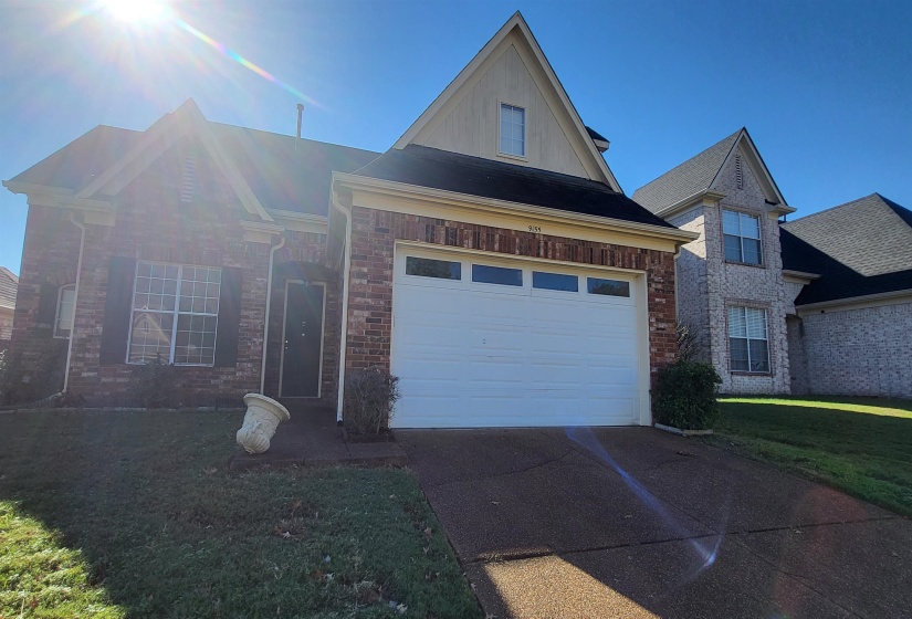 View of front facade featuring a front yard and a garage