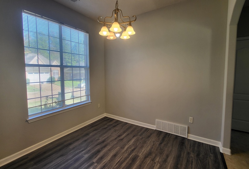 Spare room with a chandelier and dark hardwood / wood-style floors