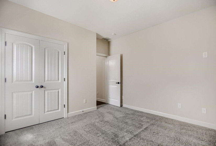 Neutral-toned room featuring a soft gray carpet, light beige walls, and white trim