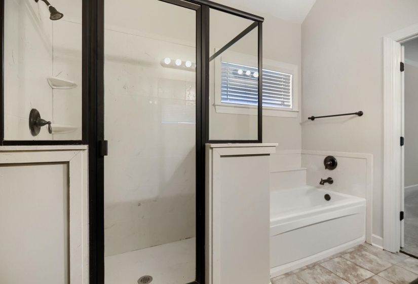 Bathroom featuring a separate shower with black-framed glass enclosure, white shower surround with integrated shelving, and oil-rubbed bronze fixtures