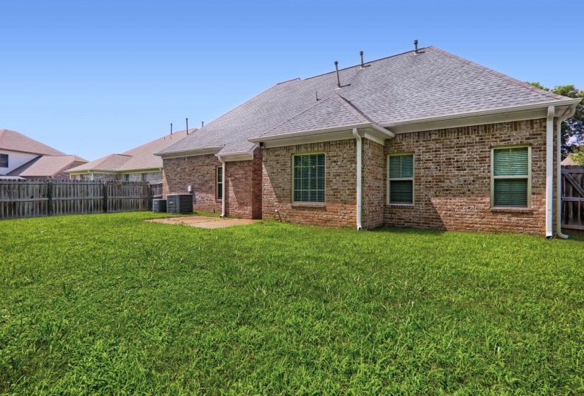 Expansive green lawn with a full brick exterior