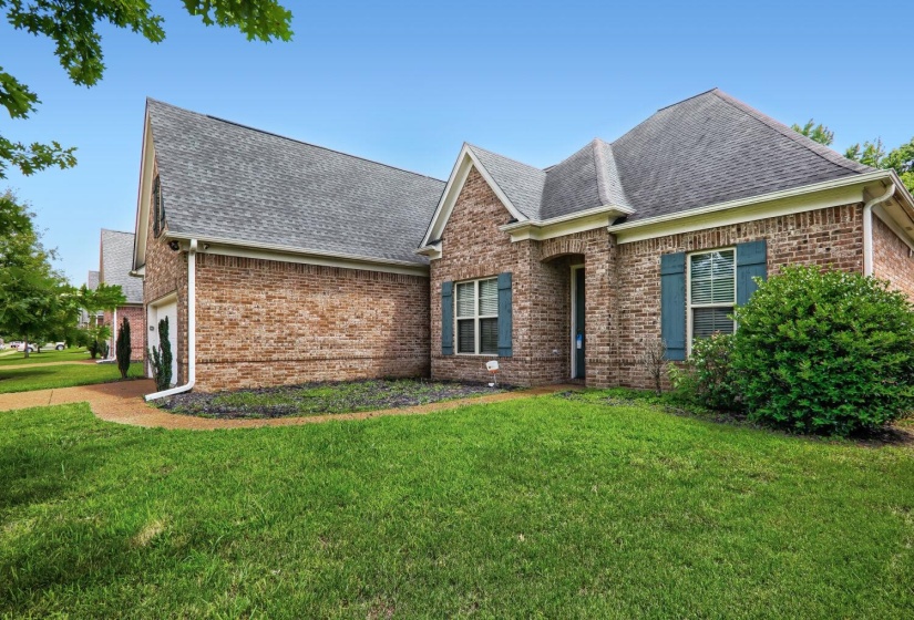 Traditional brick exterior featuring a multi-gabled roofline and blue decorative shutters