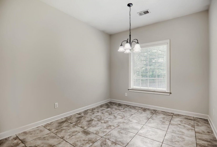 Neutral wall paint, tile flooring, and a single window with blinds