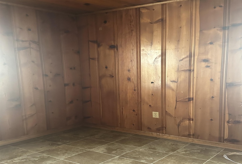 Wood paneling throughout, complemented by a tiled floor and baseboard trim