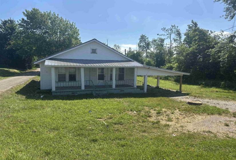 White siding residence with a covered front porch featuring white support columns and a metal roof