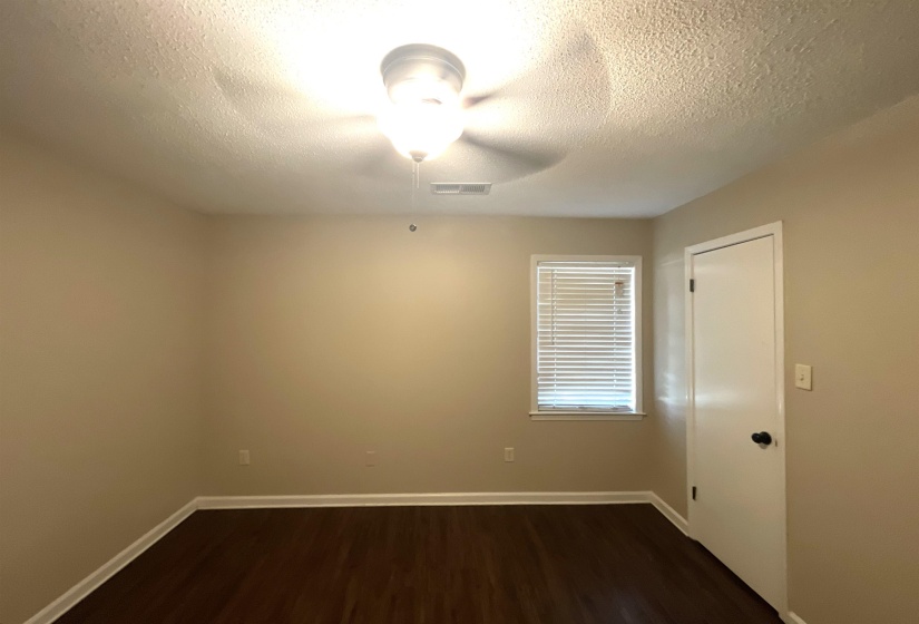 Interior room featuring wood-finish flooring, light neutral wall paint, and white baseboards