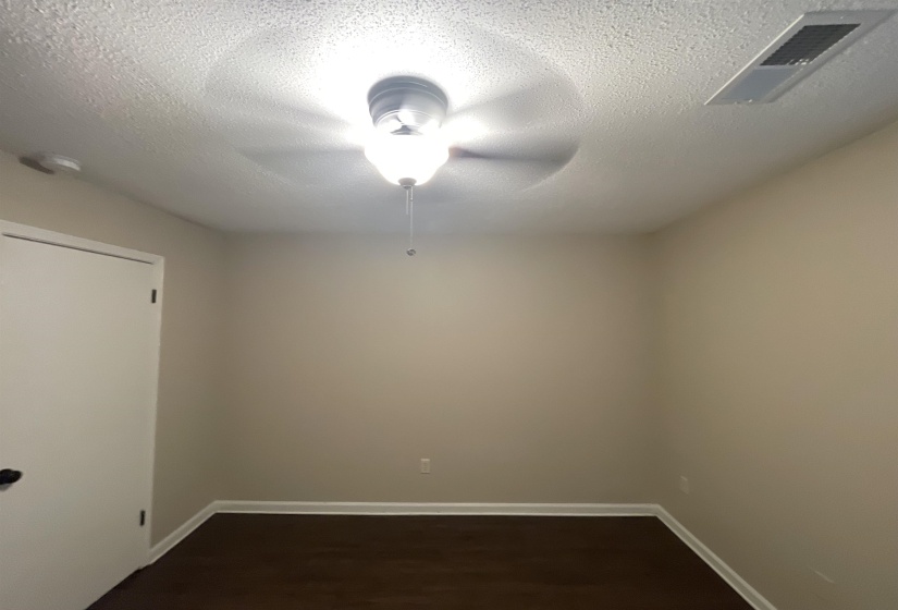 Interior room featuring a ceiling fan with integrated lighting, wood-finish flooring, and a neutral wall color