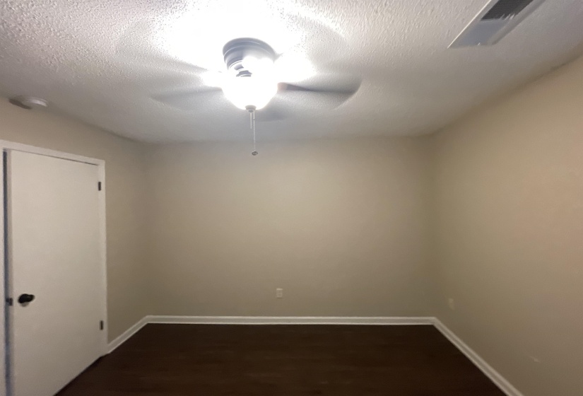 Room featuring wood-finish flooring, light-toned walls, and white baseboards