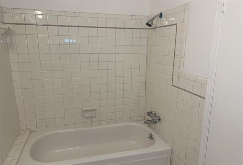 White ceramic tile bathtub surround with a contrasting border tile