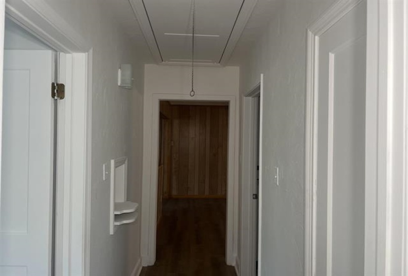 Hallway with light-toned walls, white trim, and doors