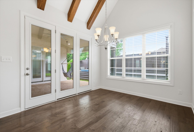 Vaulted ceilings with exposed beams complement the wood-finish flooring