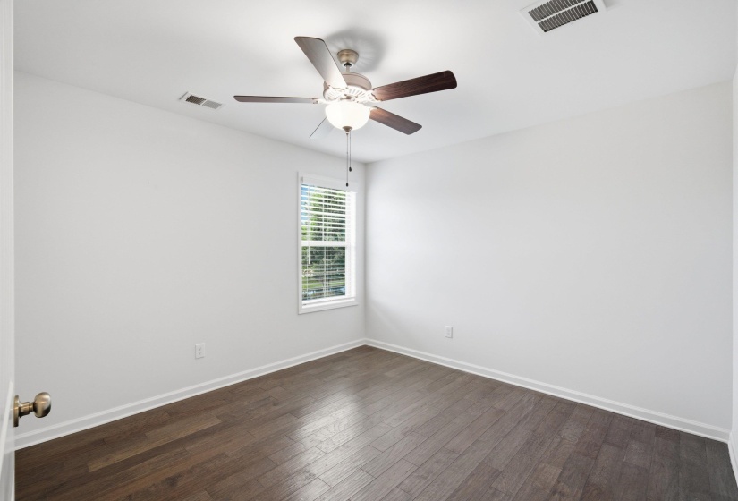 Interior room featuring wood-finish flooring, white walls, and a single window with blinds