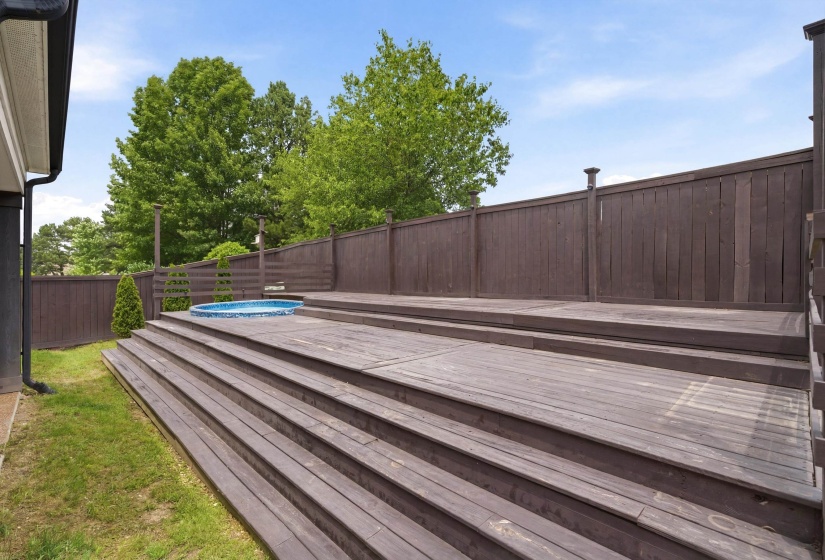 Multi-level wood-finish decking featuring a built-in circular spa