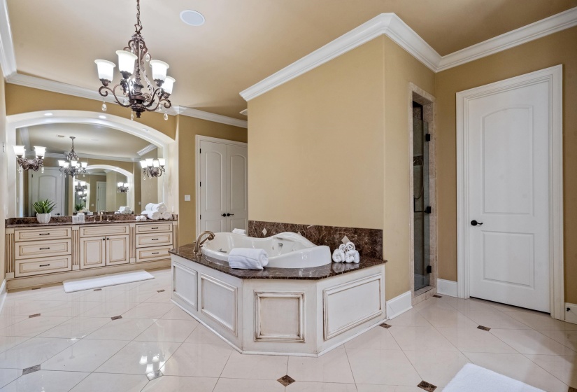 Corner garden tub with surrounding dark stone countertop
