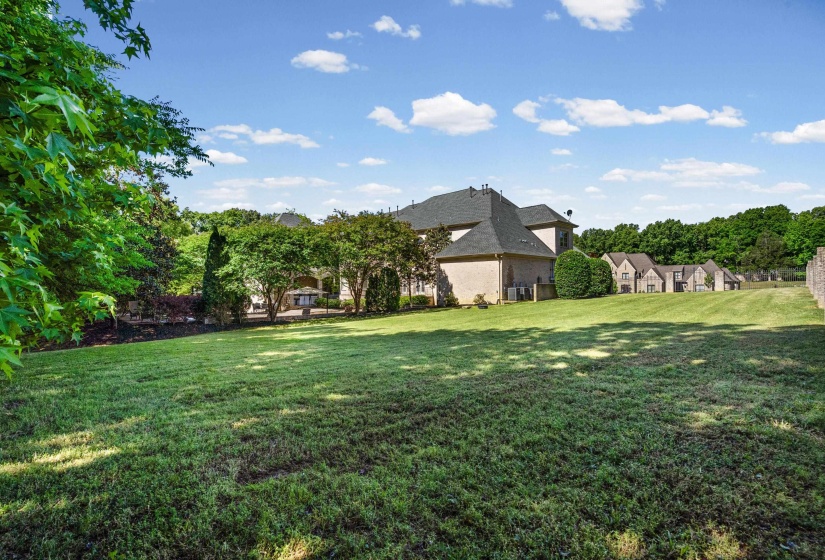 Expansive green lawn with a gentle slope leading to the rear of the property