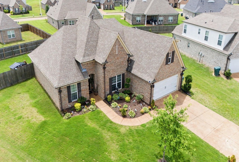 Brick exterior residence featuring a two-car garage, concrete driveway, and a landscaped front walk