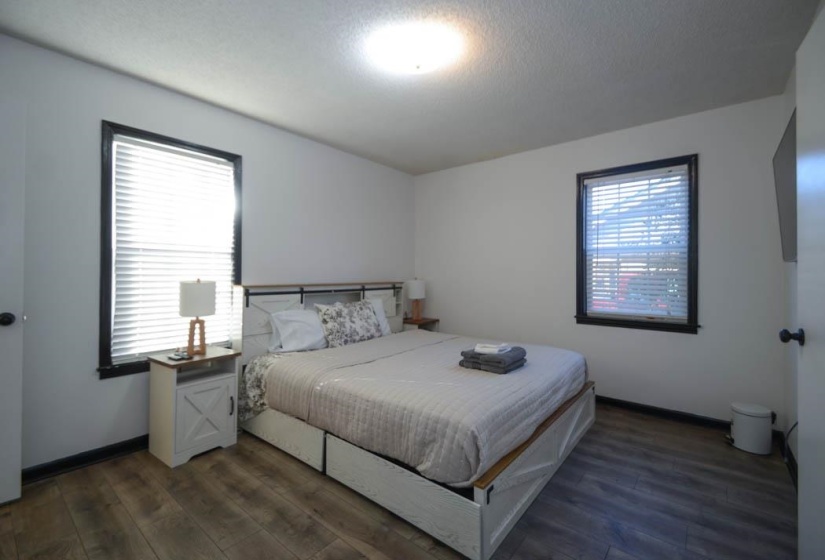 Room featuring wood-finish flooring, white walls, and a ceiling light fixture
