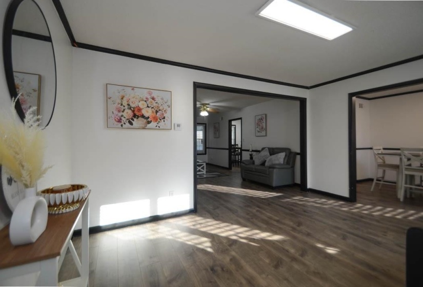Open interior featuring wood-finish flooring and white walls with dark trim