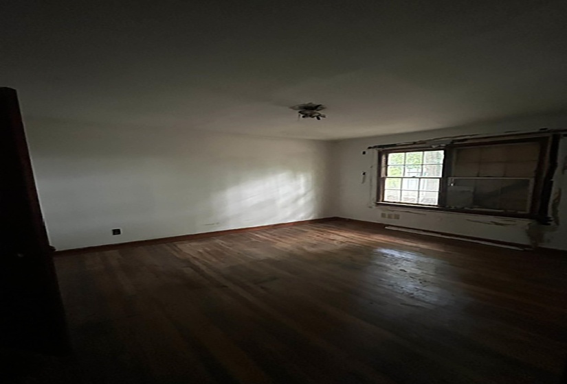 Hardwood flooring throughout a room featuring a window with exterior views