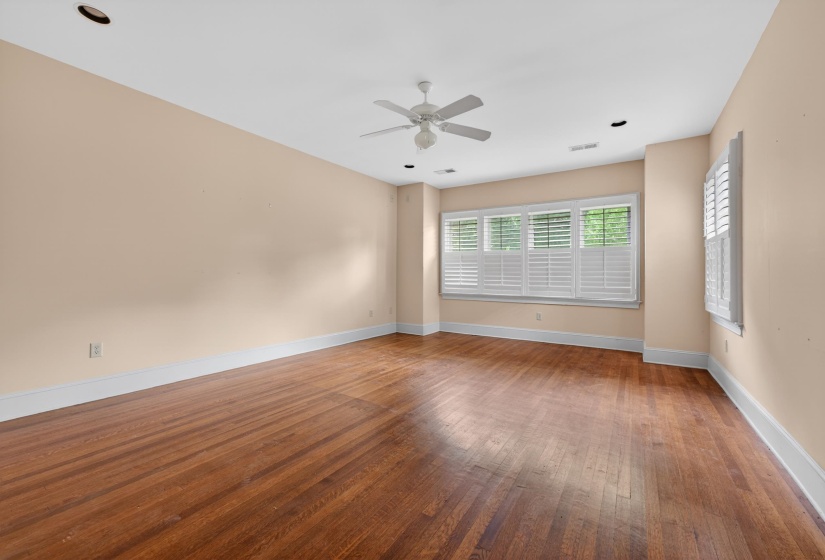 Spacious room featuring wood-finish flooring, recessed lighting, and a ceiling fan