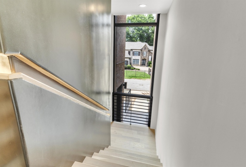 Stairs featuring wood finished floors, expansive windows, and recessed lighting