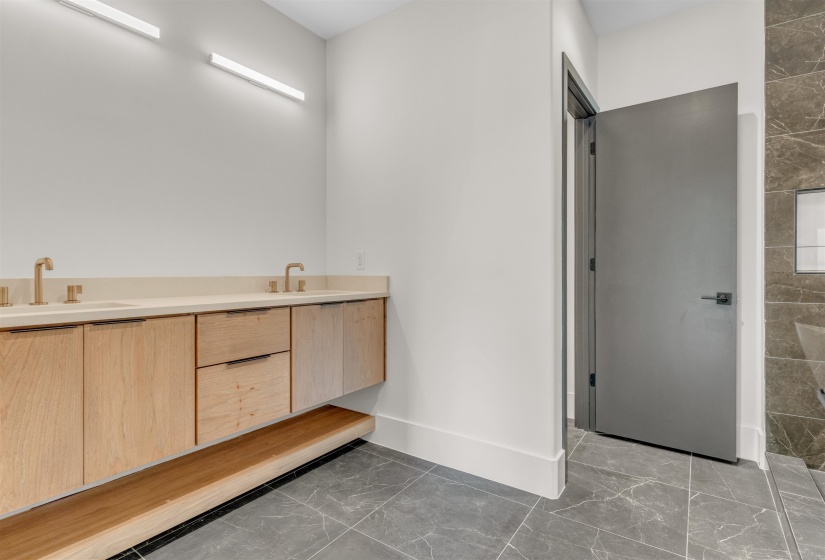 Full bathroom featuring marble look tiles and double vanity