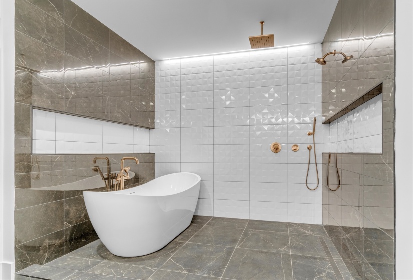 Full bathroom with tile walls, walk in shower, a soaking tub, and marble finish floors