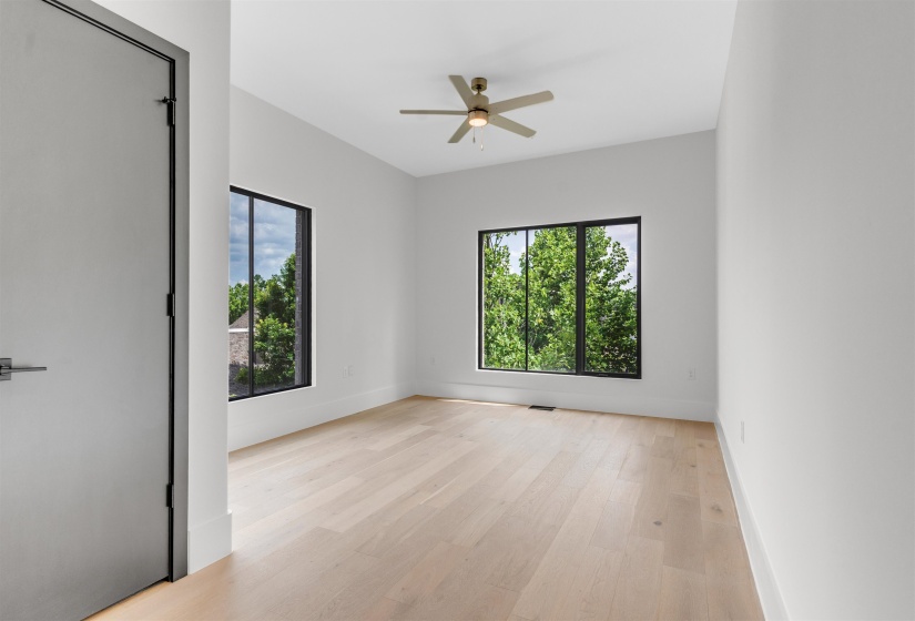 Empty room with ceiling fan and light wood-style flooring