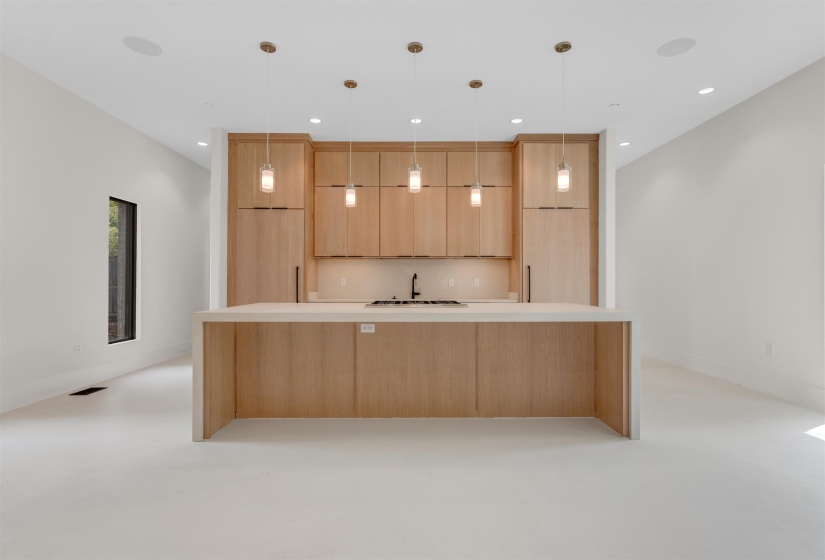Kitchen featuring modern cabinets, light brown cabinetry, light countertops, pendant lighting, and recessed lighting