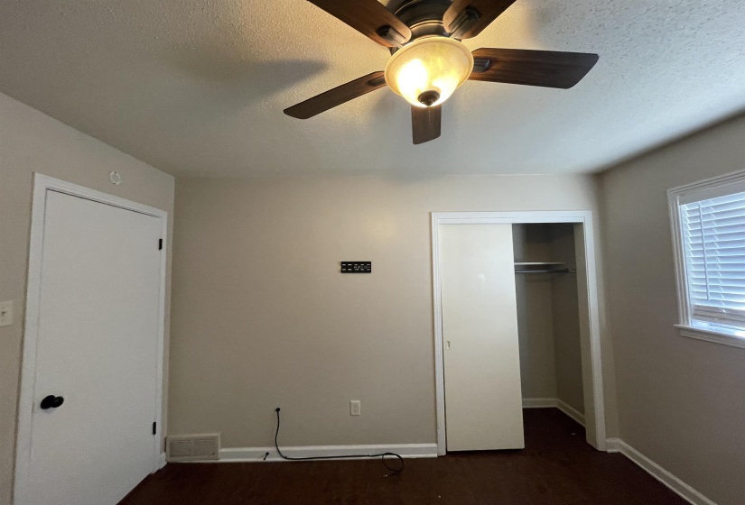 Interior room featuring wood-finish flooring, a ceiling fan with integrated lighting, and neutral wall paint