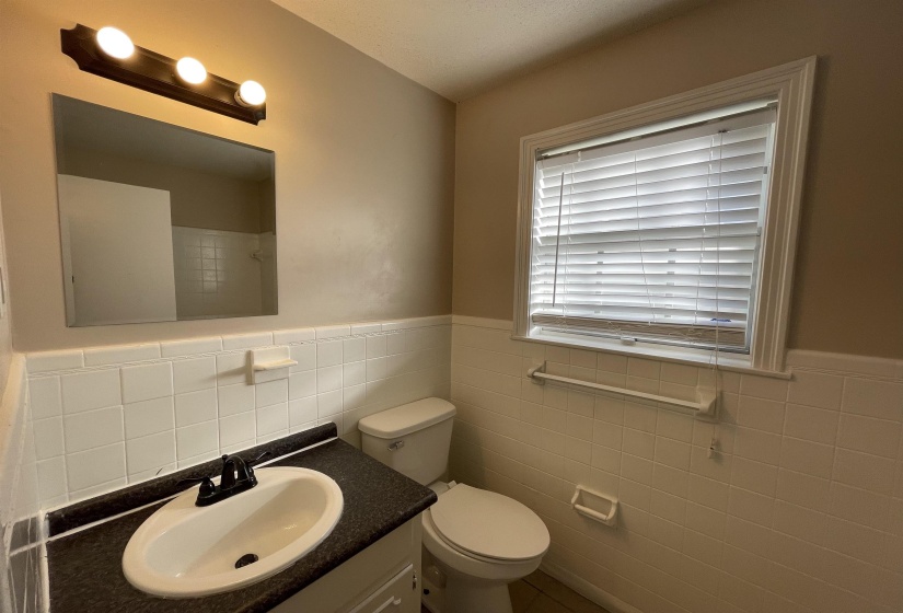 Bathroom featuring a vanity with an integrated sink, dark countertop, and matte black faucet