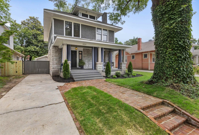 Craftsman-style exterior with stone and siding facade, a covered front porch, and a brick pathway
