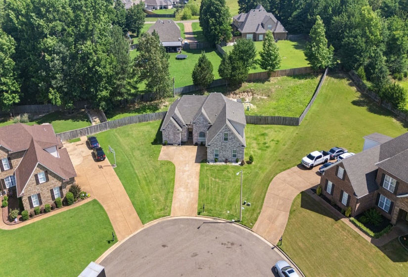 Stone facade residence featuring a front-facing attached garage and a wide driveway
