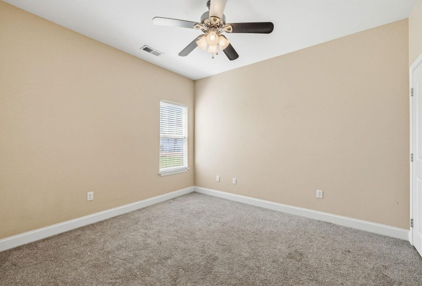 Neutral-toned room featuring light beige walls and gray carpeting