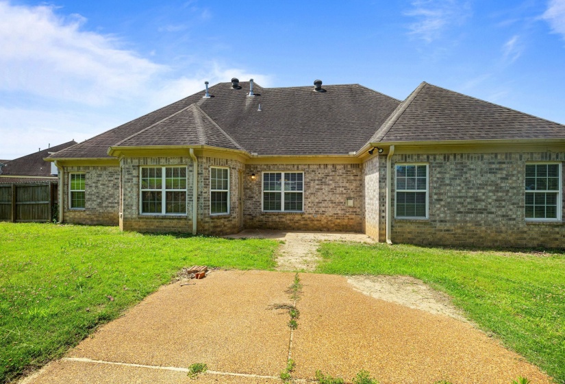 Brick exterior with multiple windows and a shingle roof
