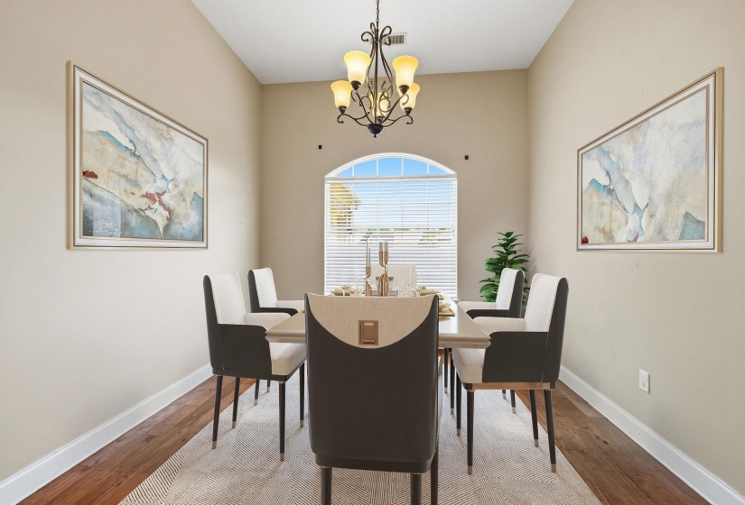 Formal dining area featuring a vaulted ceiling and wood-finish flooring