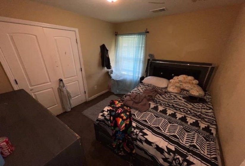 Room featuring hard surface flooring, a window with blinds, and a bi-fold closet door