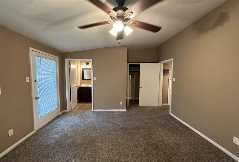 Carpeted room with vaulted ceilings and a ceiling fan