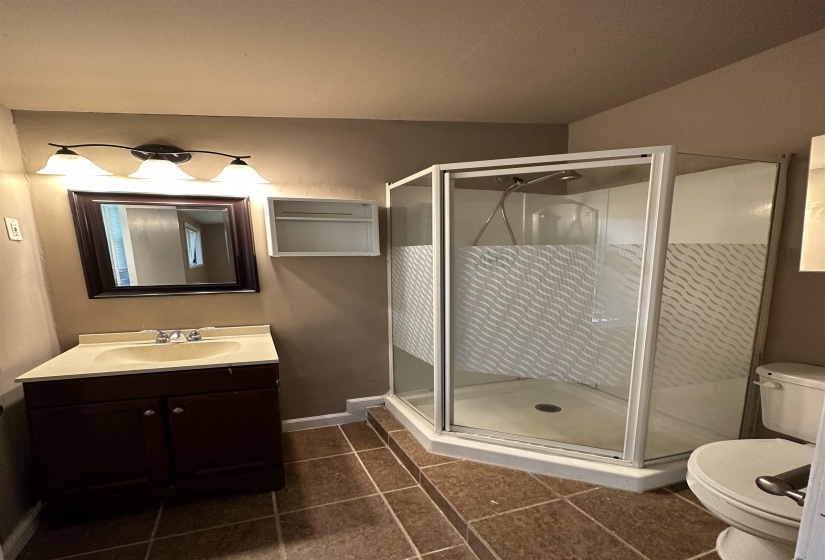 Corner shower with patterned glass enclosure and white base
