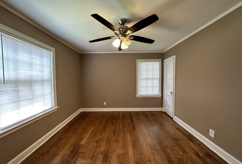 Hardwood flooring throughout, complemented by a ceiling fan with integrated lighting